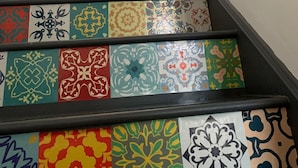 A staircase with colorful, patterned tiles leading to a door. - The Rabbit Hole - Kinlochbervie (Kinlochbervie)