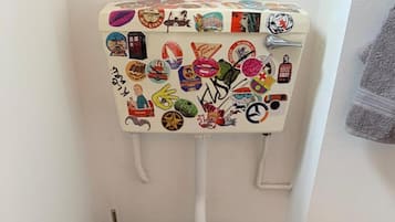 Inodoro con asiento y tapa decorados con varios adhesivos.
