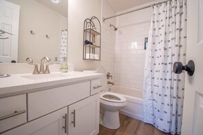Bañera, secador de pelo, toallas, shampoo
