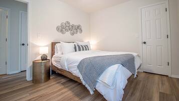 Ein Schlafzimmer mit Bett, Nachttischlampe, Deckenventilator und Wanddekoration.