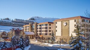 A hotel with multiple floors, a stone facade, and a clock on the front. - Cozy Pet-friendly King Studio In Mt. Crested Butte Condo - No Cleaning Fee! by RedAwning (Crested Butte)