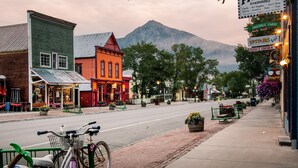 A street view with buildings, a bicycle, and a mountain in the background. - Cozy Pet-friendly King Studio In Mt. Crested Butte Condo - No Cleaning Fee! by RedAwning (Crested Butte)