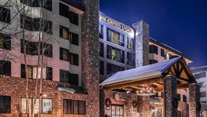 A hotel with a stone facade, a covered entrance, and a sign reading "The Grand Lodge". - Grand Lodge 1-Bedroom Condo with 3 Queens & Close to Everything 1 Condo - No Cleaning Fee! by RedAwning (Crested Butte)