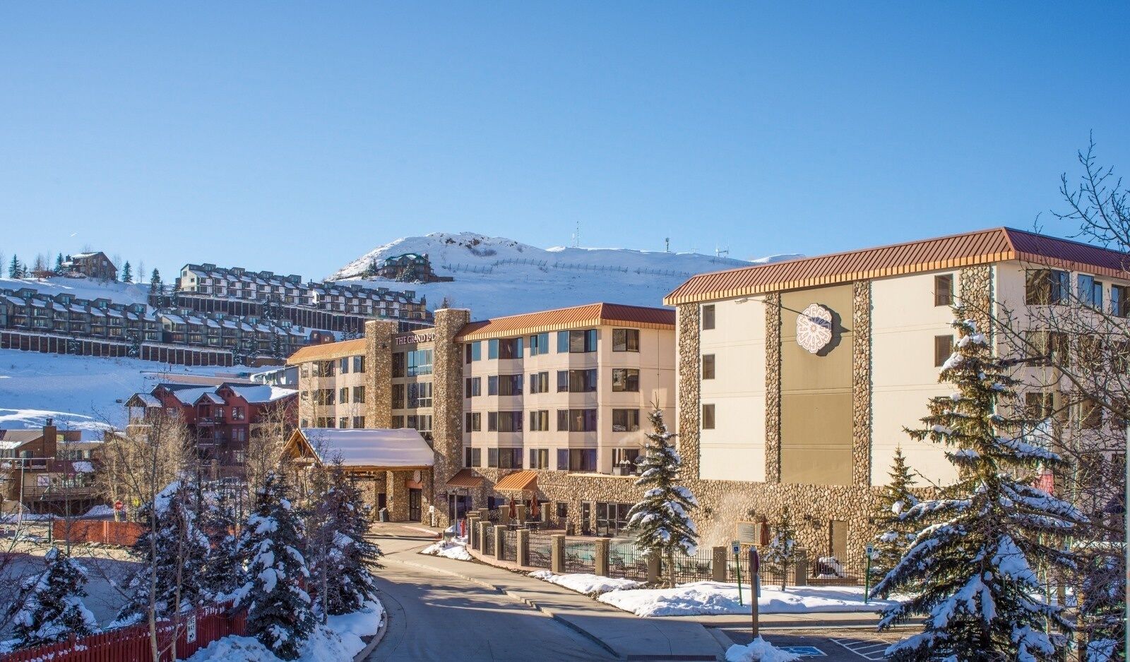 A hotel with multiple floors, a stone facade, and a clock on the front.
