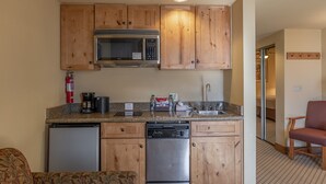 A compact kitchen with wooden cabinets, a microwave, a dishwasher, and a refrigerator. - Grand Lodge Condo In The Heart Of Mt Crested Butte 1 Bedroom Condo - No Cleaning Fee! by RedAwning (Crested Butte)