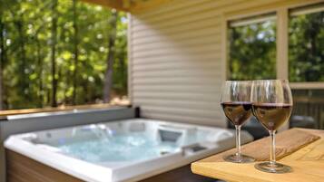 Un jacuzzi con dos copas de vino sobre una mesa de madera.