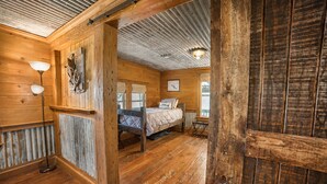 Una habitación rústica de madera con una cama, una lámpara y una ventana.