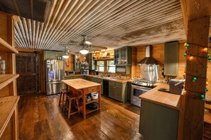 A kitchen with wooden cabinets, a central island, and a ceiling fan.