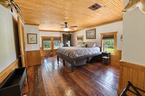 A bedroom with a wooden ceiling, a bed, a ceiling fan, and a window with a view of the outdoors. - Escape to Calcasieu Lake Lodge-Premier Fishing and Family Getaway (Lake Charles)