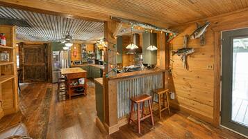 Ein rustikales Holzinterieur mit Barbereich, Holzböden und einem an der Wand aufgehängten Fisch.