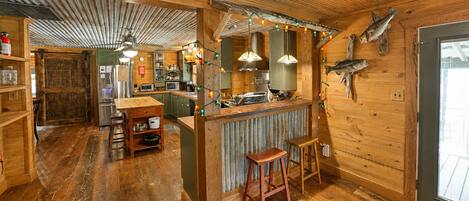 A rustic wooden interior with a bar area, wooden floors, and a fish mounted on the wall.