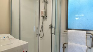 A glass-enclosed shower area with a handheld showerhead and a handheld shower attachment. - A delightful studio in idyllic Mapua Village, perfect from which to explore the Tasman region (Mapua)