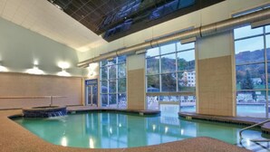An indoor swimming pool with clear views of the outside, a hot tub, and a windowed wall. - Hot SKI-in SKI-out Rentals Bentley Brook Resort! (Hancock)