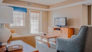 A hotel room with a bed, a desk with a lamp, a television, and a window with blinds. - Hot SKI-in SKI-out Rentals Bentley Brook Resort! (Hancock)