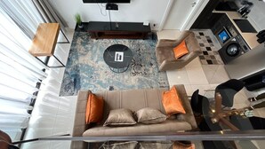 Un salon moderne avec un canapé, une table basse et un téléviseur.