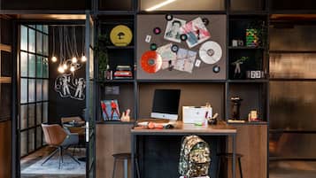 A modern office space with a desk, computer, and shelves with vinyl records and decorative items.