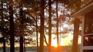 Une vue sur le lac, avec une terrasse en bois, un petit bâtiment et un ciel dégagé.