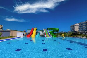 A swimming pool with multiple colorful slides and a clear blue sky. - Palmora Lara Hotel - All inclusive (Antalya)