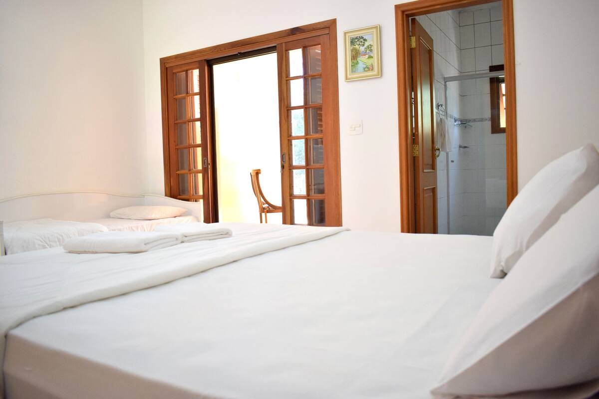 Une chambre d’hôtel avec un lit, une chaise et un espace douche.