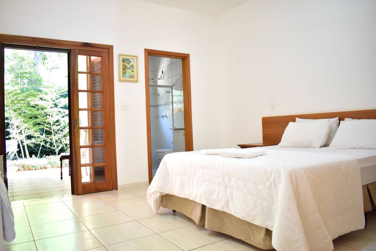 Une chambre à coucher avec un lit, une porte en bois et une vue sur l’extérieur.