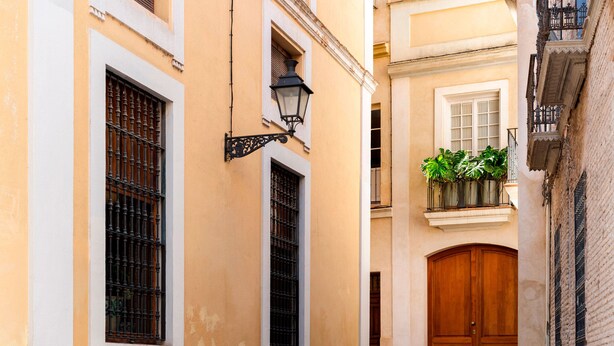 A narrow street with a wooden door and a window with a metal grille. - Genteel Home Pasaje Santa Cruz II (Seville)