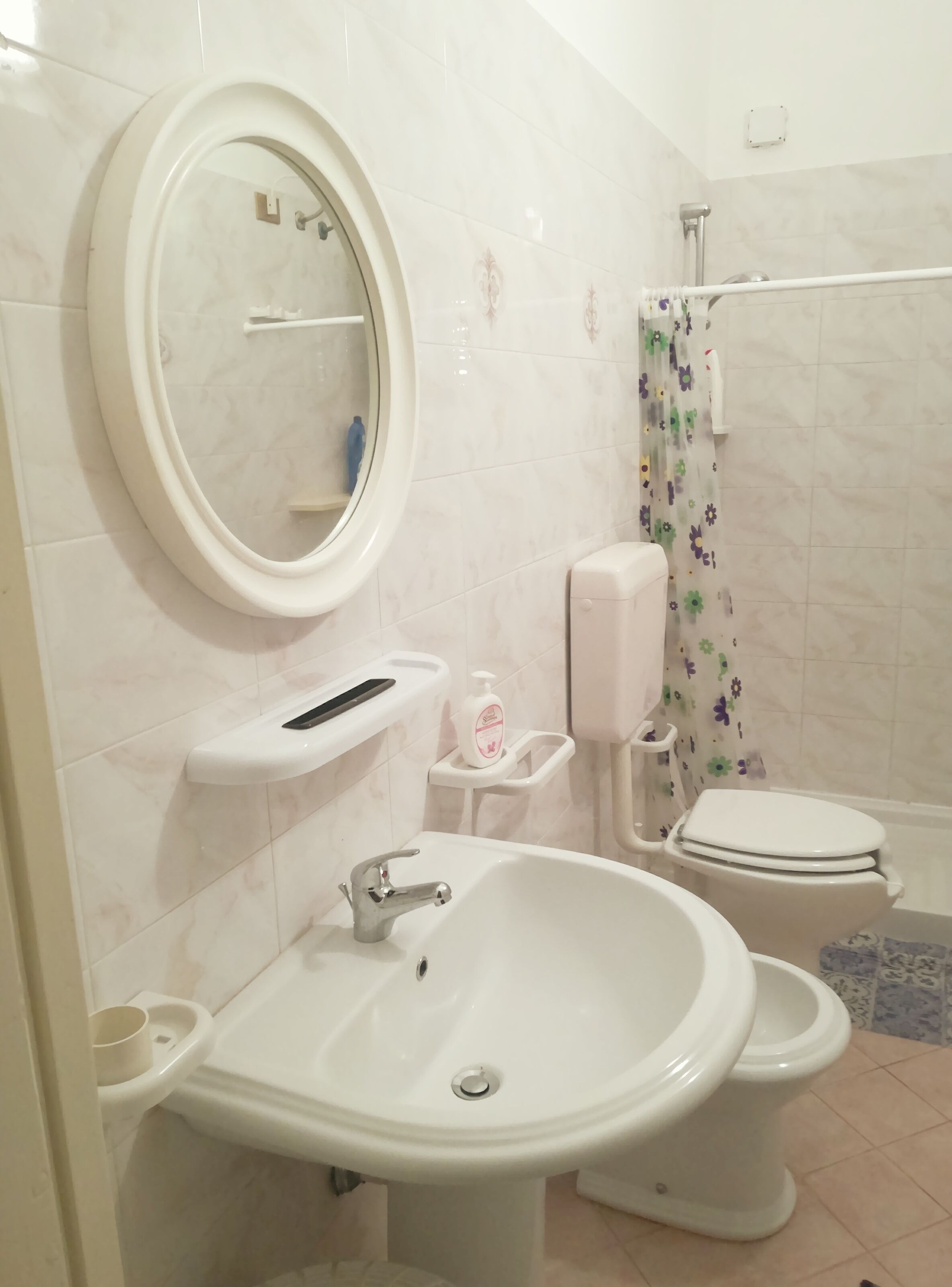 Un baño con lavamanos, inodoro y ducha.