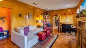 A cozy living room with a sofa, ottomans, a bookshelf, and a fireplace. - 《Best Austin Location ❤Huge Patio w HEATED Cowboy Pool & 65" TV❤ Skyline Views》 (Austin)