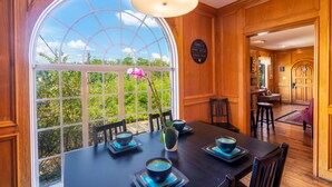 A dining area with a large window, wooden paneling, and a table set for four. - 《Best Austin Location ❤Huge Patio w HEATED Cowboy Pool & 65" TV❤ Skyline Views》 (Austin)