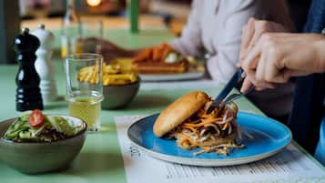 A dining table with a plate of food, a bowl of salad, and a glass of water.