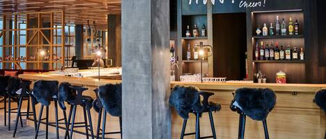 A bar area with wooden stools and a bar counter.