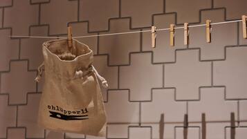 A clothespin bag hanging on a line with a geometric patterned wall in the background.