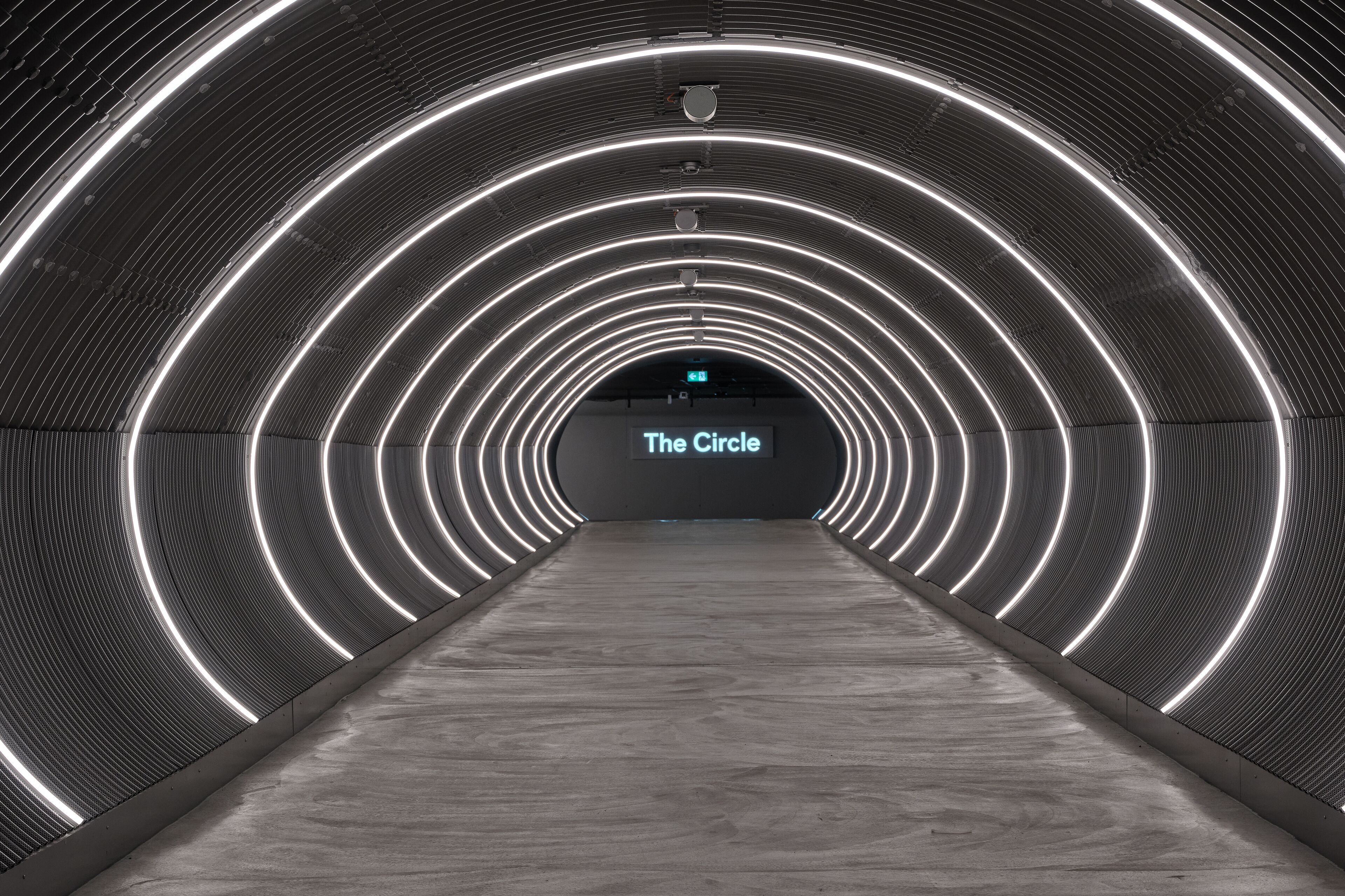 A tunnel with circular light patterns and a sign reading "The Circle".