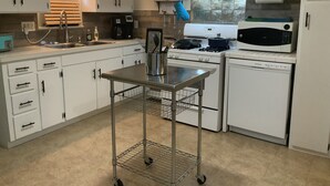 A kitchen with white cabinets, a stove, a microwave, and a sink. - Clean Cozy Bungalow on THE BACK STRETCH Close to Oaklawn Racing and Casino (Hot Springs)