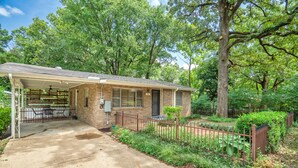 A single-story house with a covered porch, a brick exterior, and a fenced yard. - Clean Cozy Bungalow on THE BACK STRETCH Close to Oaklawn Racing and Casino (Hot Springs)