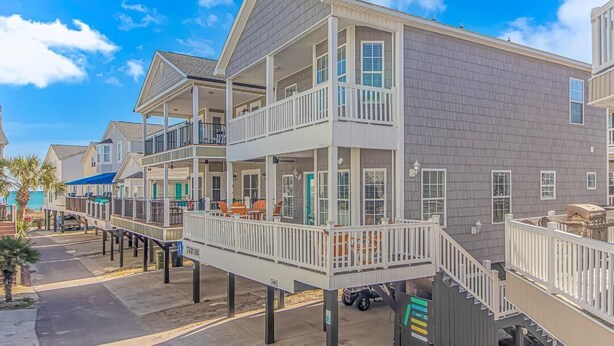 A beachfront residential building with multiple balconies, a covered walkway, and a view of the ocean. - COCONUT TREEHOUSE, 5 bed/3.5 bath, 1 minute walk to beach, Holiday Inn section (Myrtle Beach)