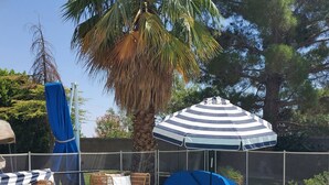 A pool area with lounge chairs and an umbrella. - PRIVATE OASIS-MONTHLY RENTAL/ POOL/SPA/GOLF/WIFI/PARKING/REVIEWS! (Las Vegas)