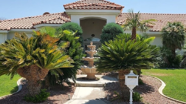 A building with a tiled roof, a central fountain, and palm trees. - PRIVATE OASIS-MONTHLY RENTAL/ POOL/SPA/GOLF/WIFI/PARKING/REVIEWS! (Las Vegas)