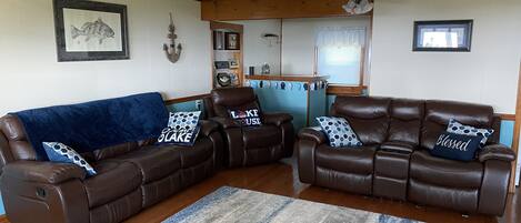 A living room with brown leather sofas, a blue blanket, and a patterned rug.