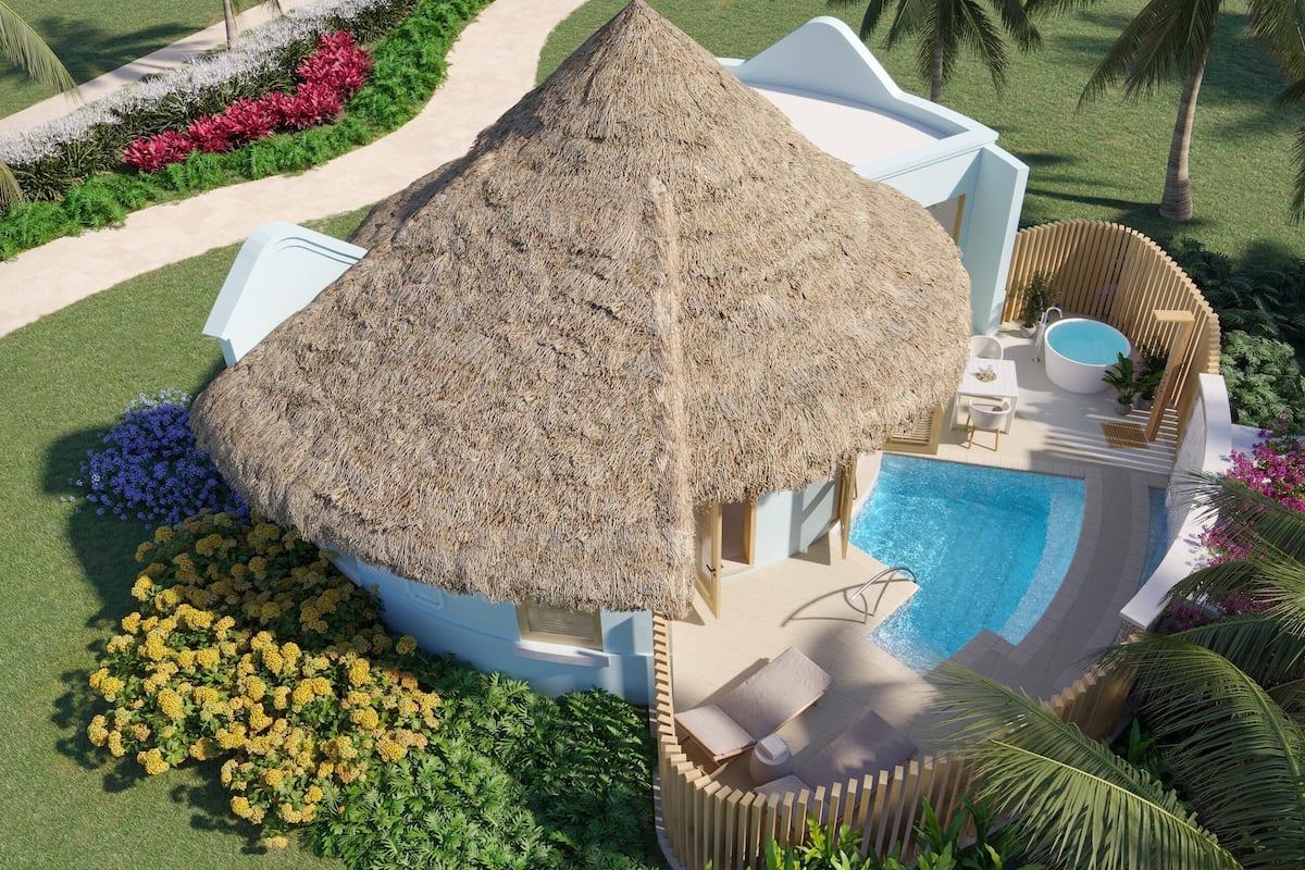 Eine Villa mit einem Reetdach und privatem Pool, umgeben von üppiger Vegetation und Palmen.