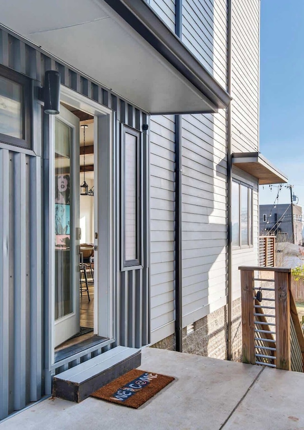 A modern house with a welcoming entrance, a visible kitchen area, and a small outdoor seating space.