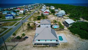 Une zone résidentielle côtière comprenant des maisons, une route et une plage.
