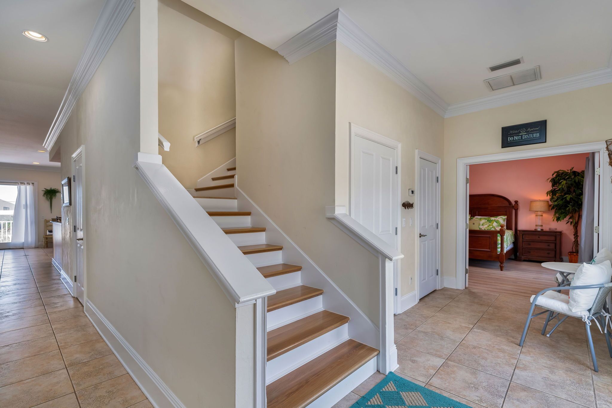 A home interior with a staircase, a dining area, and a bedroom.