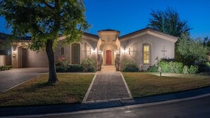 A residential house with a central entrance, a driveway, and a well-maintained lawn.