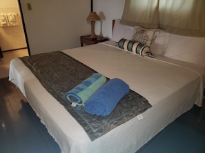 Restful retreat with a neatly made bed, featuring a comfortable bedspread and a decorative pillow.
