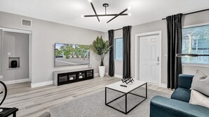 A modern living room with a flat-screen TV, a coffee table, and a sofa. - Madison Suite 2 BD/2BA Miami Beach Lincoln Casa (Miami Beach)