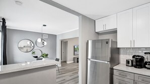A modern kitchen with a stainless steel refrigerator, white cabinets, and a countertop with a coffee maker. - Madison Suite 2 BD/2BA Miami Beach Lincoln Casa (Miami Beach)