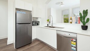 A modern kitchen with a stainless steel refrigerator, a dishwasher, and a sink. - Stunning Sydney Home 8 (Millers Point)