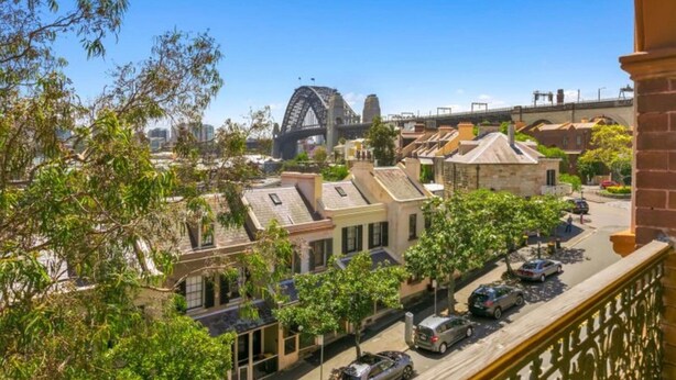 A residential area with traditional architecture, a street with parked cars, and a bridge in the background. - Stunning Sydney Home 8 (Millers Point)