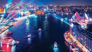 A nighttime cityscape with a prominent bridge and a brightly lit building with a unique architectural design. - Stunning Sydney Home 9 (Millers Point)