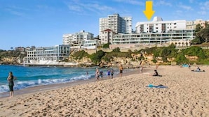 A beach with a row of buildings in the background. - Ultimate Bondi Living (Bondi Beach)